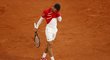 Novak Djokovič otírá pot tričkem v prvním setu finále proti Nadalovi