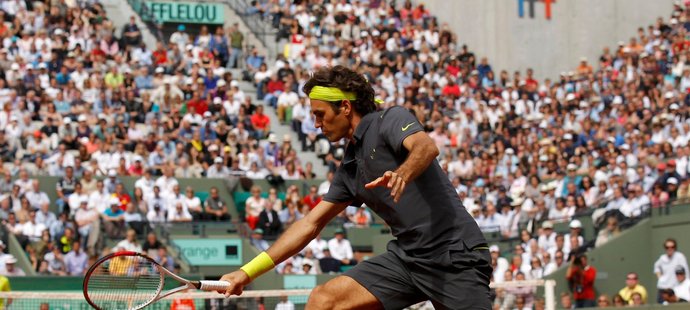 Roger Federer dobíhá a odehrává nízký balónek