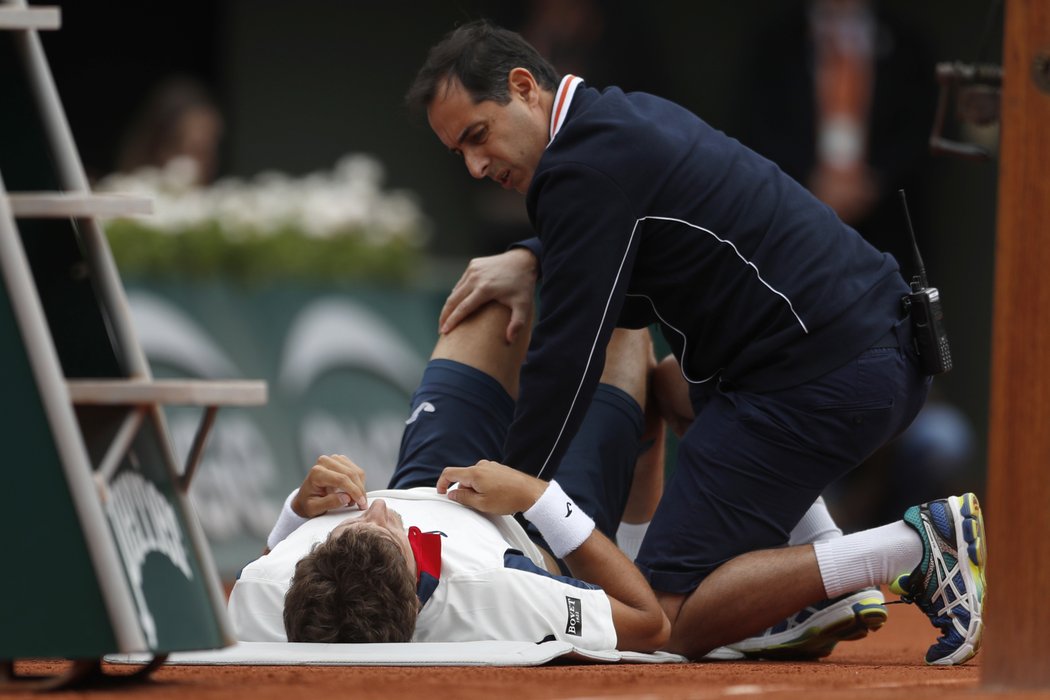 Ošetřování španělského tenisty Pabla Carreňi v utkání čtvrtfinále French Open s Rafaelem Nadalem