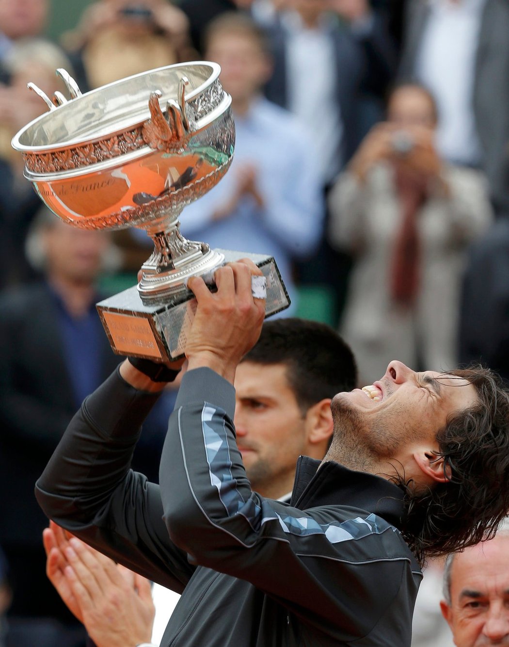 Slastný pocit: Rafael Nadal právě zvedá nad hlavu trofej pro šampiona grandslamového Roland Garros - už posedmé v kariéře