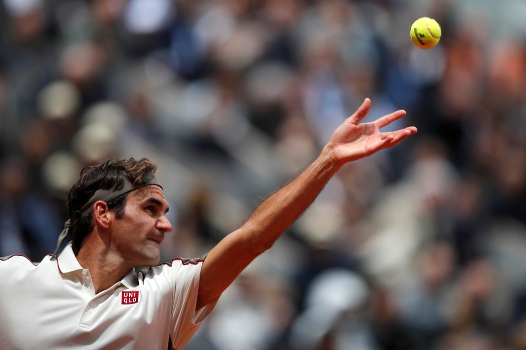 Roger Federer podává v semifinále s Rafaelem Nadalem na Roland Garros