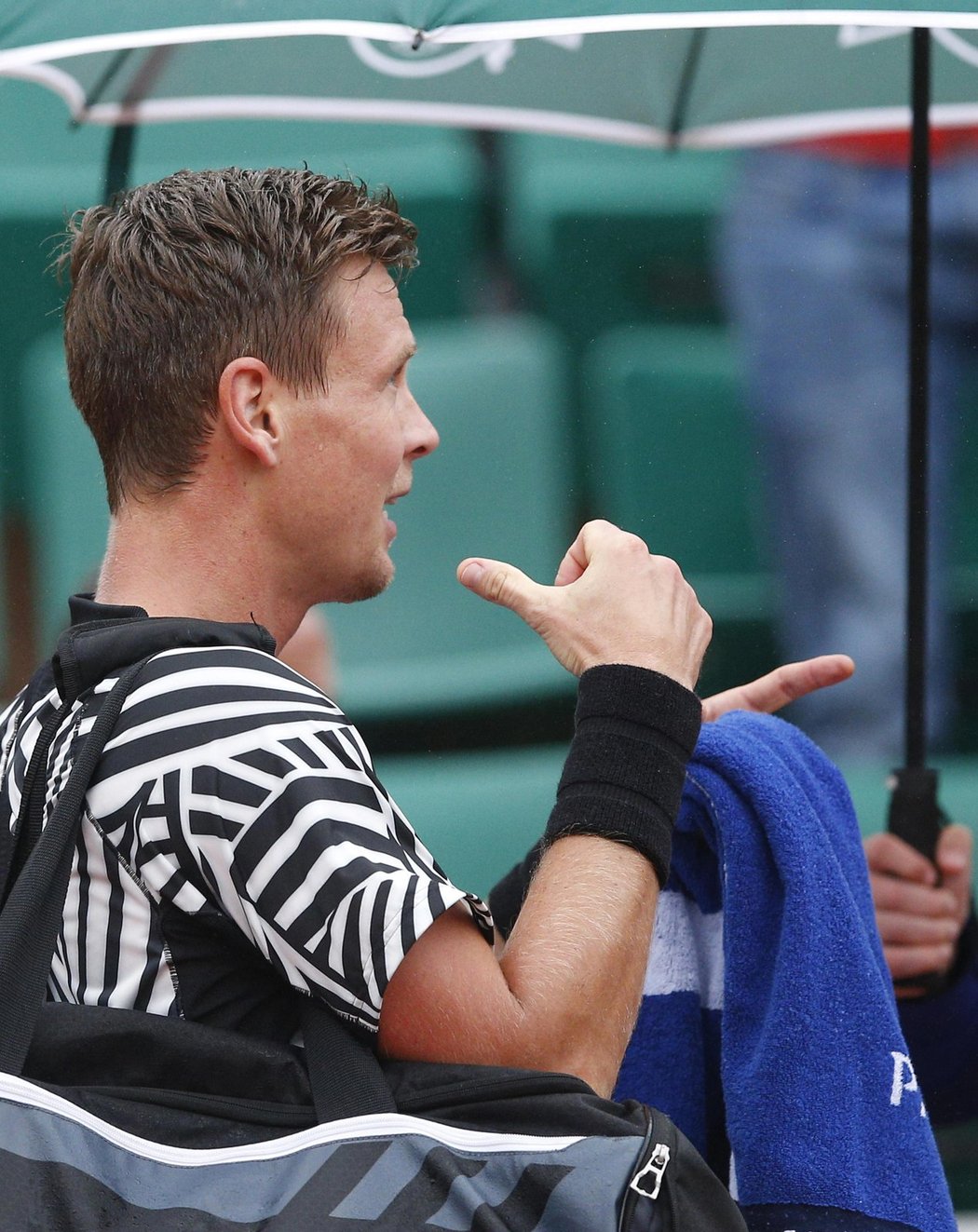 Tomáš Berdych pod deštníkem krátce poté, co rozehrál své pařížské osmifinále proti Davidu Ferrerovi