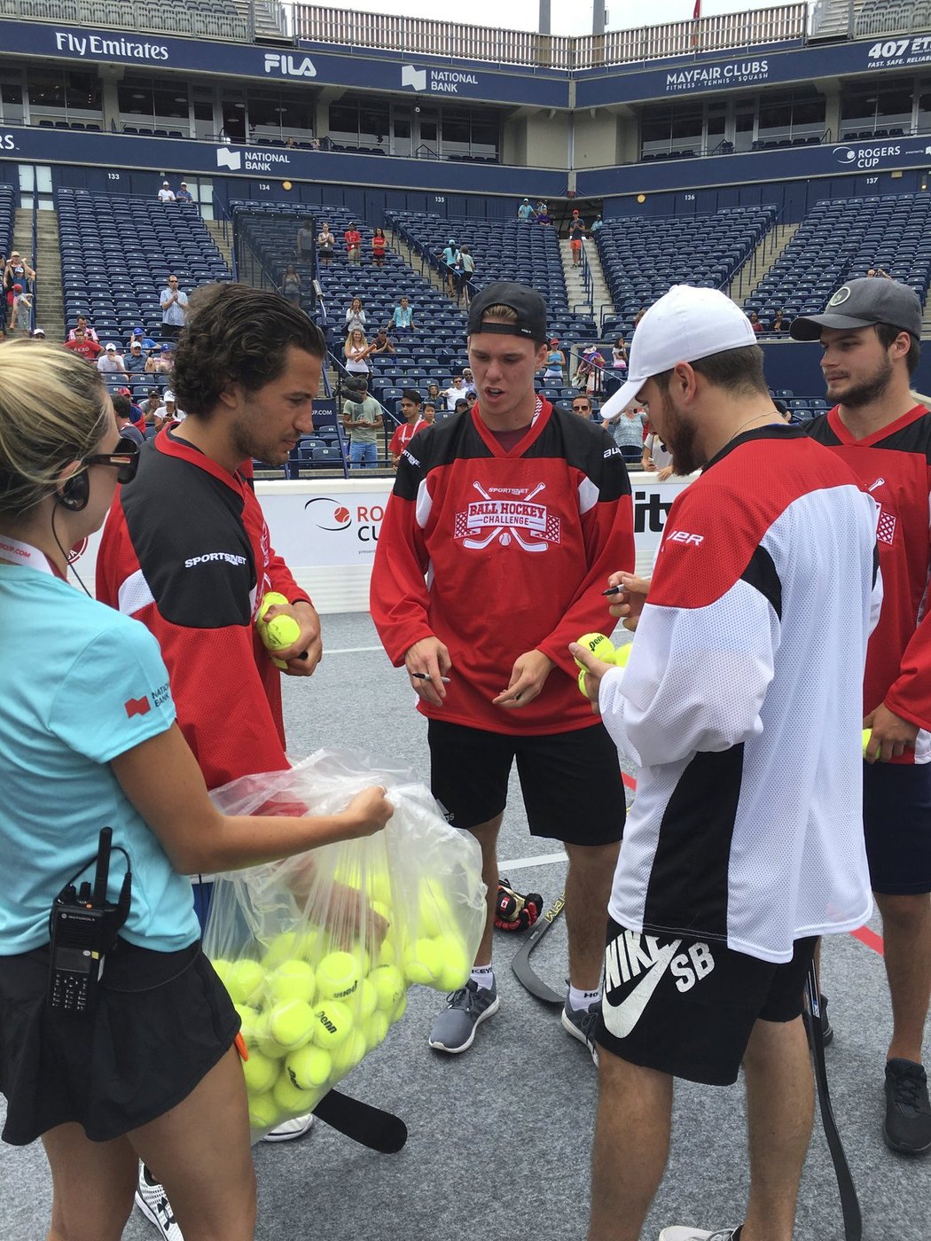 Connor McDavid (uprostřed) a další borci z NHL si nabírají míčky k podepsání