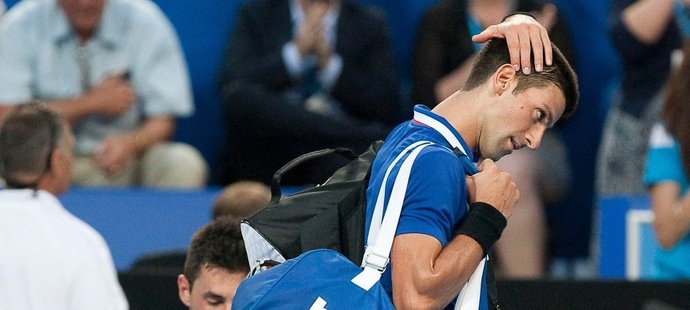 Poražený Novak Djokovič opouští kurt, zatímco jeho přemožitel Bernard Tomic si balí raketu