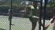 Íránský tenista Majid Abedini zuřivě kope do plotu, za kterým stojí rozhodčí zápasu.