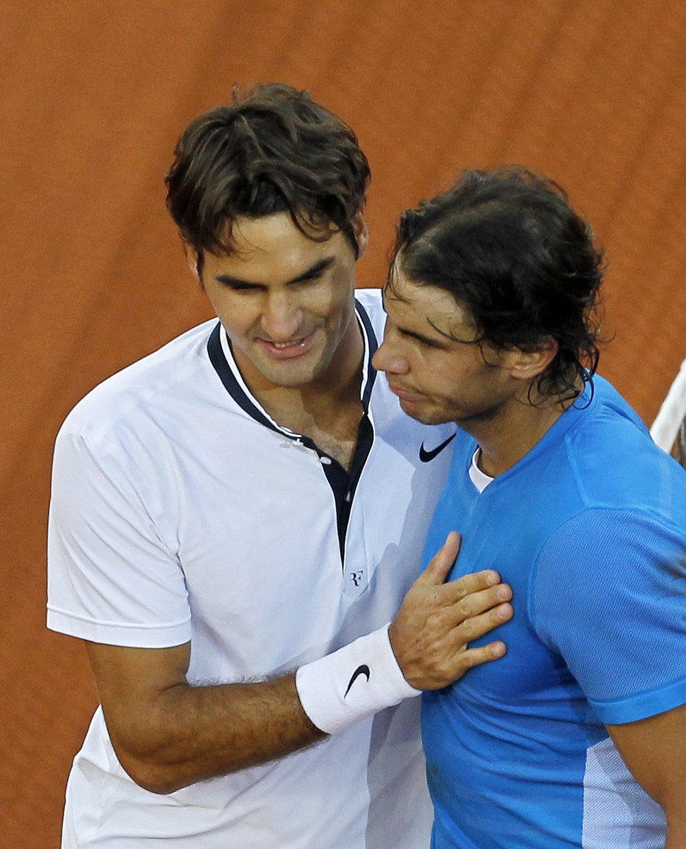 Objetí po zápase - Roger Federer (vlevo) daroval vítězství v turnaji Rafaelu Nadalovi málo vídaným kiksem