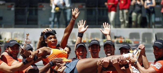 Serena Williamsová v rukou podavačů míčku po svém vítězství ve finále turnaje v Madridu