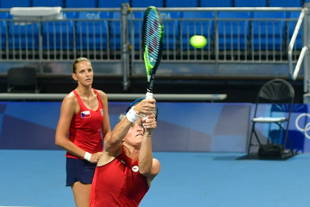 Těžká smeč z bekhendu v podání Markéety Vondroušové. Plíšková přihlíží