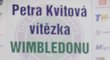 Petra Kvitová ukazuje, kde je vyrytý její podpis na zmenšené wimbledonské trofeji