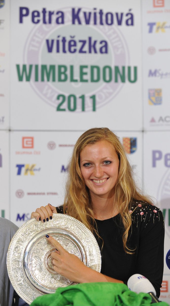 Petra Kvitová ukazuje, kde je vyrytý její podpis na zmenšené wimbledonské trofeji