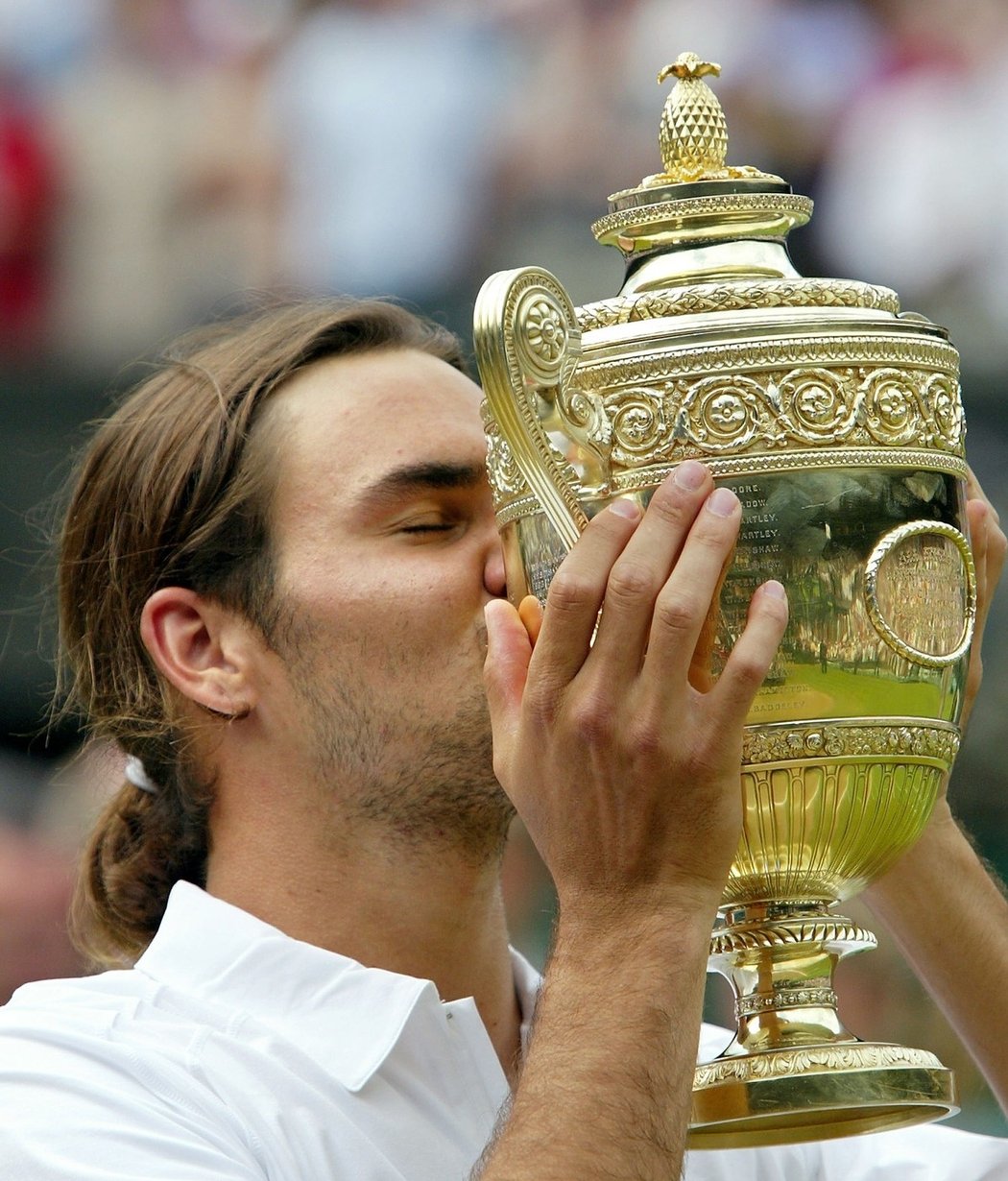 První pusa pro wimbledonskou trofej. Roger Federer se svým culíkem slaví triumf v Old England Clubu v roce 2003