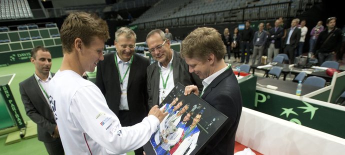 Tomáš Berdych podepisuje fotografii českého daviscupového týmu, kterou od tenistů dostal darem pražský primátor Tomáš Hudeček (vpravo) při návštěvě otevřeného tréninku