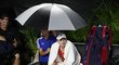 Elena Rybakinová pod deštníkem po přerušení zápasu se Sabalenkovou