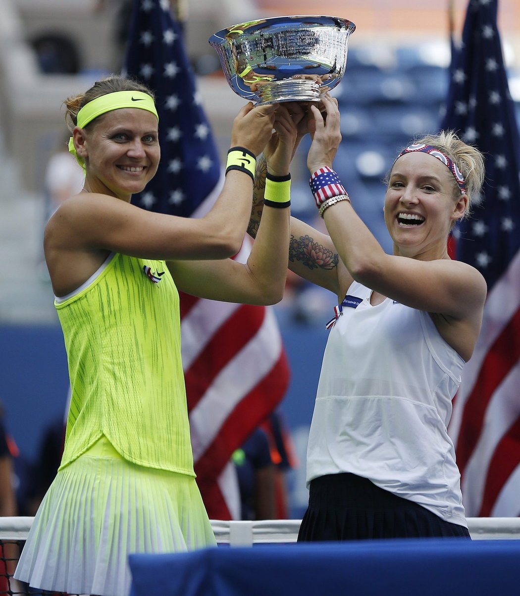 Vysmáté parťačky Lucie Šafářová s Bethanií Mattekovou-Sandsovou zvedají pohár pro vítězky US Open