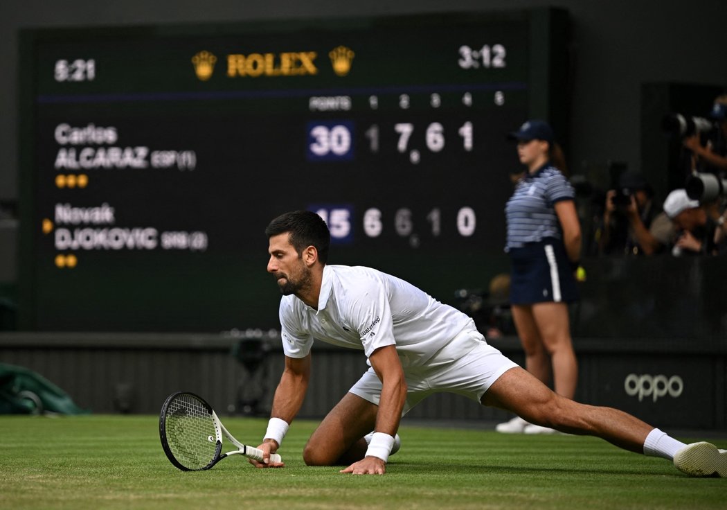 Novak Djokovič se zvedá po pádu při finále Wimbledonu