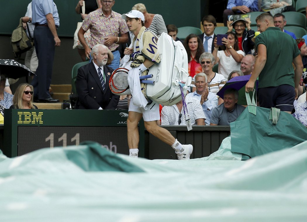 Andy Murray odchází z centrálního kurtu, když jeho zahajovací zápas Wimbledonu přerušil déšť