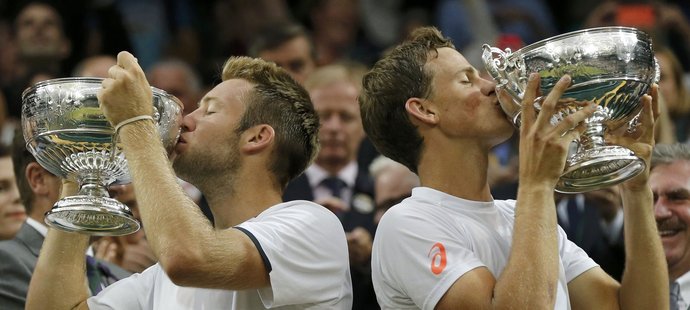 Kanaďan Vasek Pospisil (vpravo) a Jack Sock líbají své trofeje pro vítěze wimbledonské čtyřhry