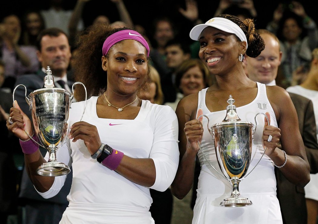 Serena Williamsová (vlevo) a její sestra Venus pózují s trofejemi pro vítězky čtyřhry ve Wimbledonu