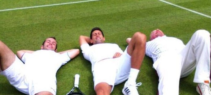 Štěpánek, Djokovič a Becker leží na wimbledonské trávě.