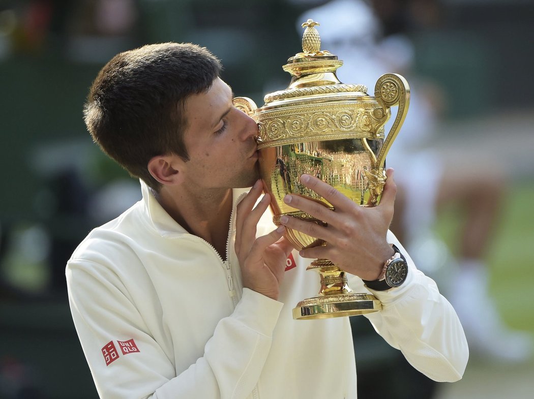 Novak Djokovič líbá pohár pro wimbledonského vítěze po triumfu nad Rogerem Federerem