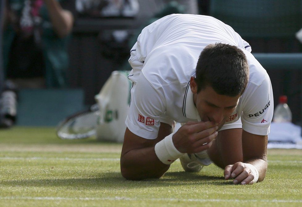 Srbský tenista Novak Djokovič pojídá po svém triumfu ve finále wimbledonskou trávu. Rogera Federera porazil 6:7, 6:4, 7:6, 5:7 a 6:4 a opět se stane světovou jedničkou.