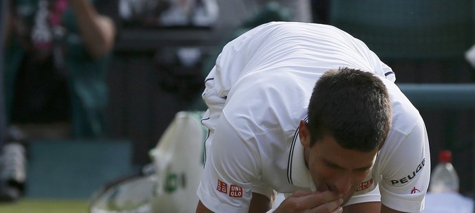 Novak Djokovič pojídá po svém triumfu ve finále wimbledonskou trávu