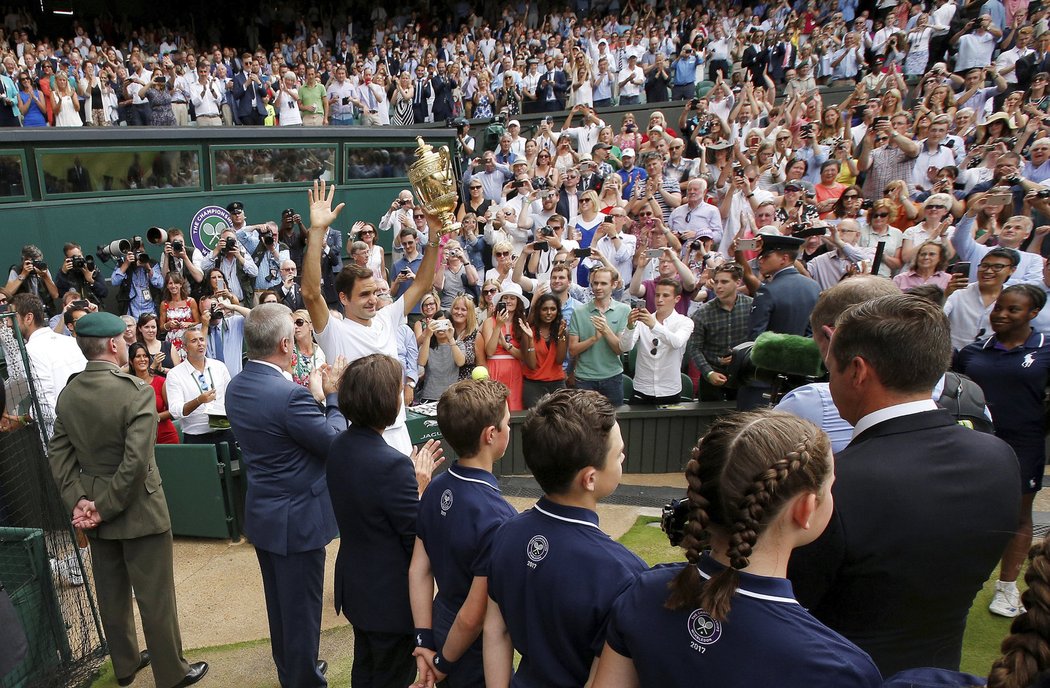 Roger Federer mává fanouškům po dalším triumfu na Wimbledonu