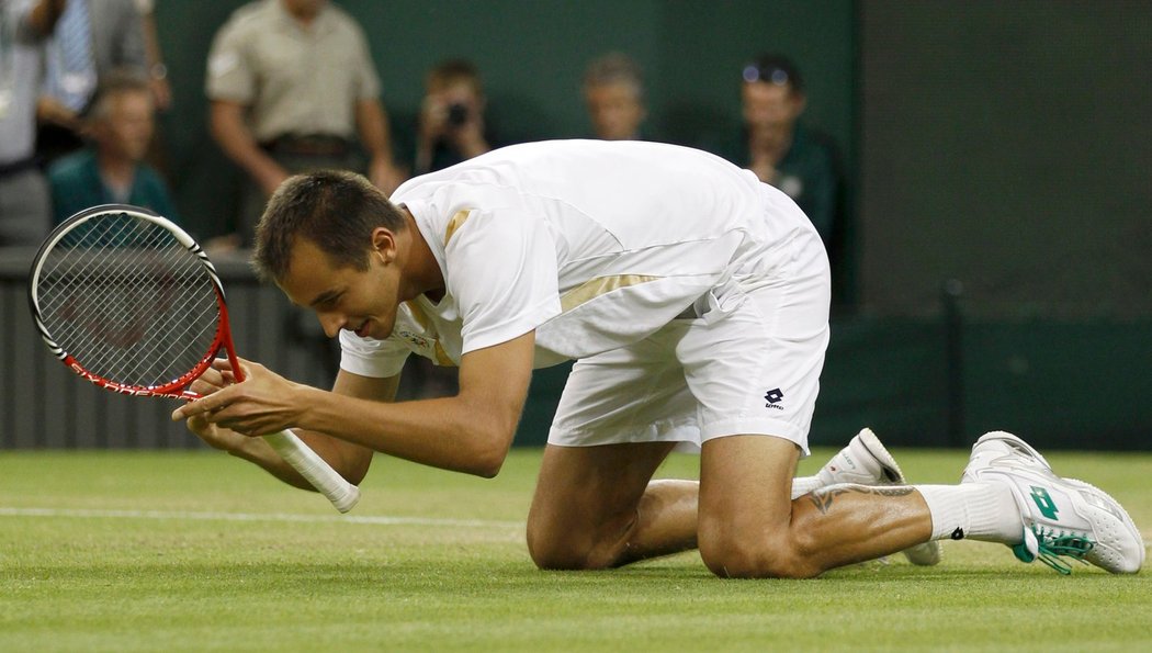 Šťastný Lukáš Rosol padá na wimbledonský trávník po vítězství nad Rafaelem Nadalem