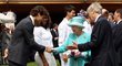 Královna Alžběta se zdraví s Rogerem Federerem. V pozadí přihlíží Serena Williamsová a Novak Djokovič