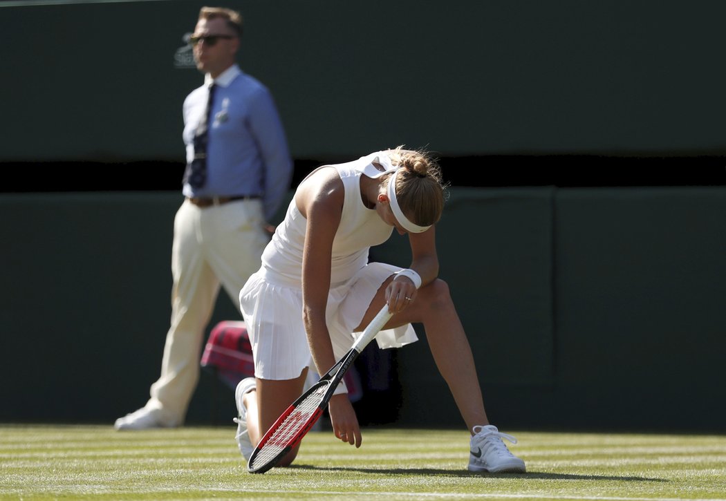 Petra Kvitová se sbírá ze země v zápase prvního kola Wimbledonu proti Bělorusce Sasnovičové