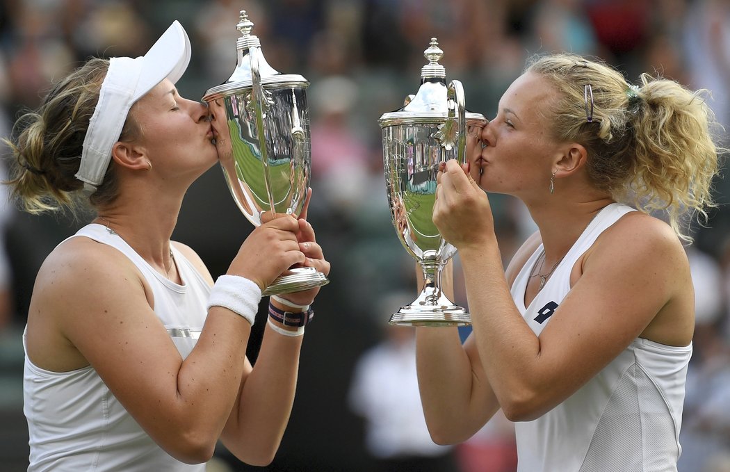 Barbora Krejčíková s Kateřinou Siniakovou líbají své poháry pro vítězky wimbledonské čtyřhry