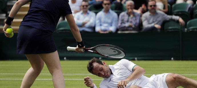 Podavačka míčků asistuje Radku Štěpánkovi u jeho zvedání po pádu v duelu prvního kola Wimbledonu proti Nicku Kyrgiosovi