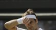 Roger Federer si otírá pot ve čtvrtfinále Wimbledonu proti Kevinu Andersonovi