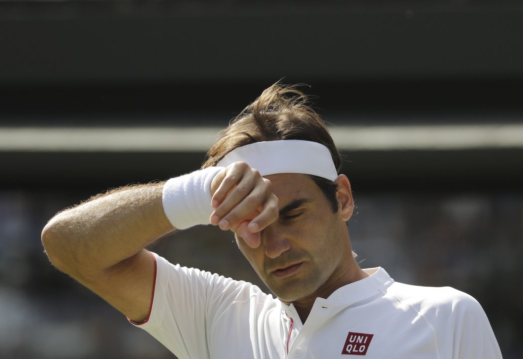 Roger Federer si otírá pot ve čtvrtfinále Wimbledonu proti Kevinu Andersonovi