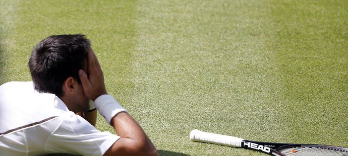 Novak Djokovič na wimbledonské trávě poté, co ho v jedné z výměn dohnal Argentinec Del Potro až na zem