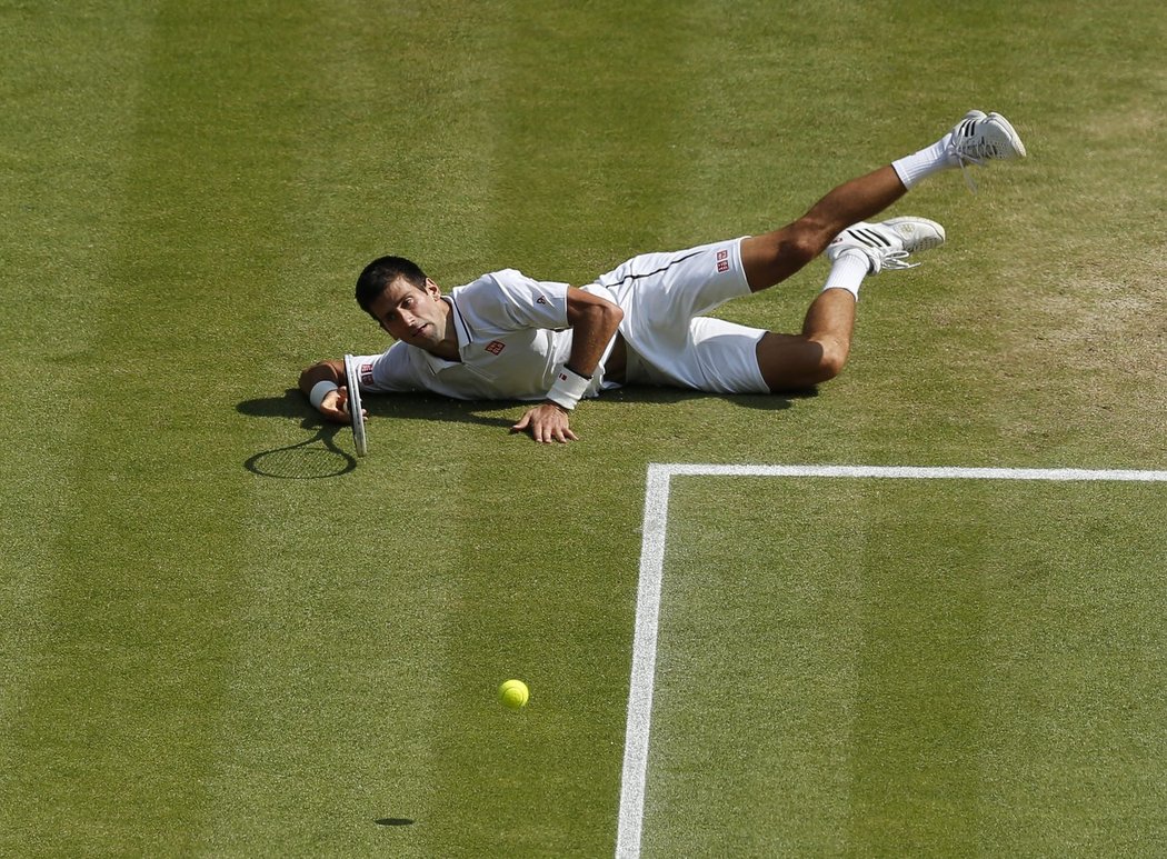 Novak Djokovič se v pozici ležícího střelce snaží odehrát míček z rakety Argentince Del Potra