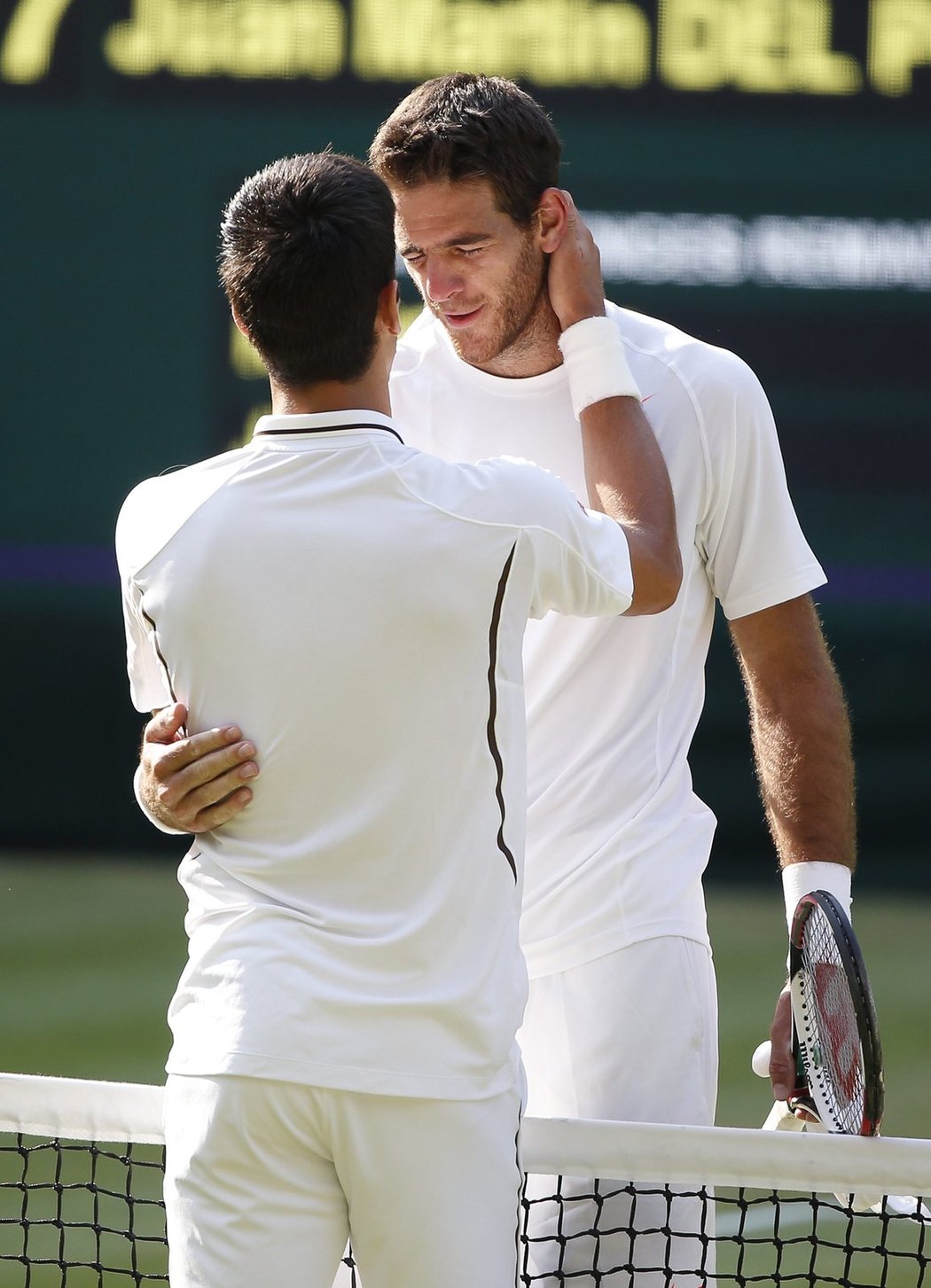 Triumfující Novak Djokovič utěšuje poraženého Juana Martina Del Potra (vpravo)