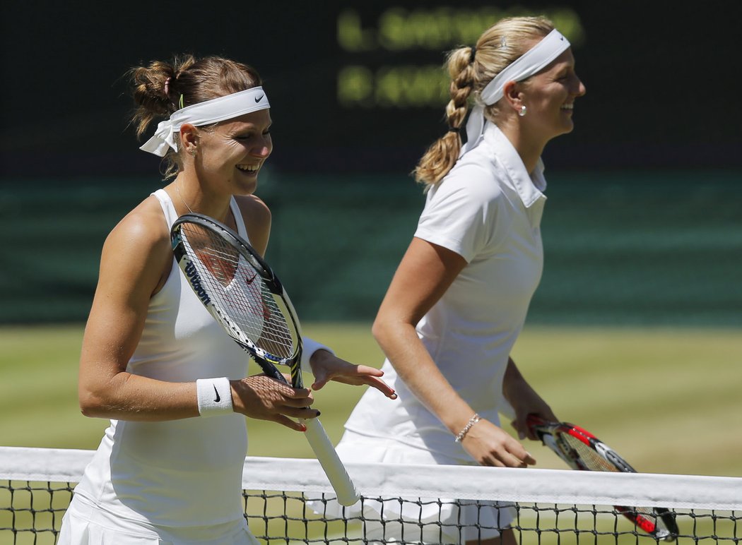 Lucie Šafářová (vlevo) a Petra Kvitové odcházejí od sítě rozesmáté po úvodním losu semifinále Wimbledonu