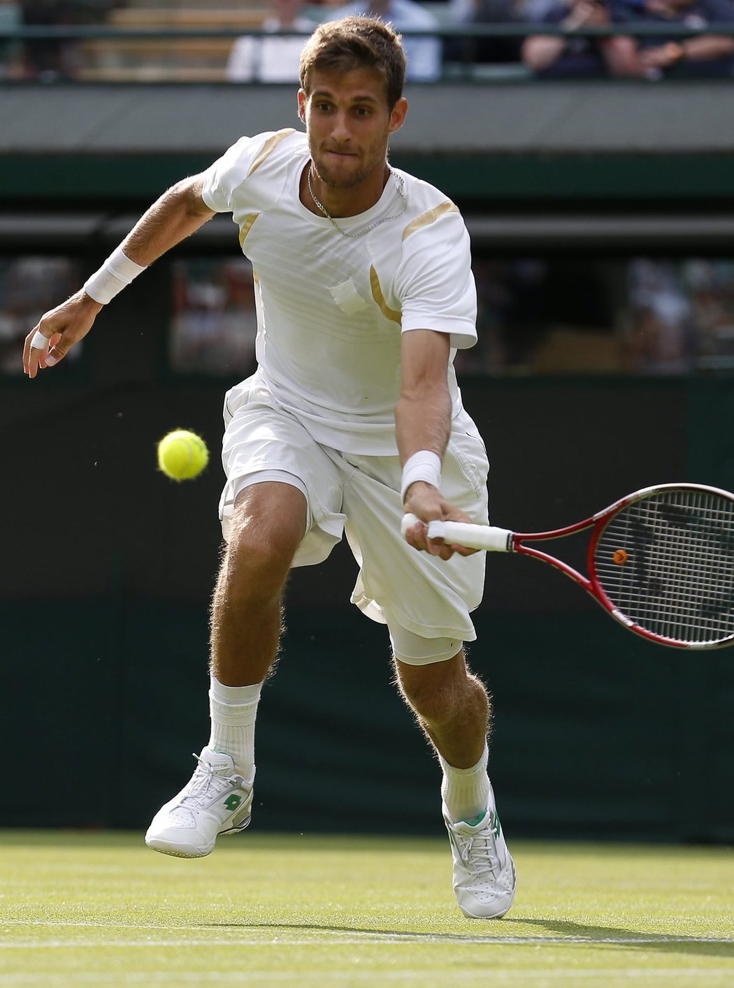 Slovenský tenista Martin Kližan dobíhá míč z rakety Tomáše Berdycha v prvním kole Wimbledonu