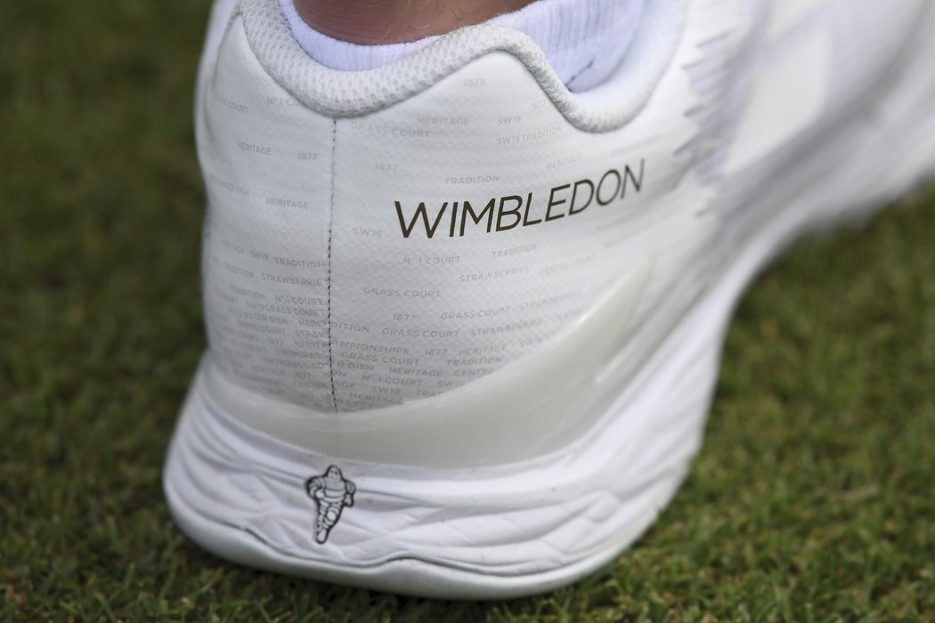 Tenisky jednoho z podavačů míčků ve Wimbledonu. Všimněte si malých nápisů...