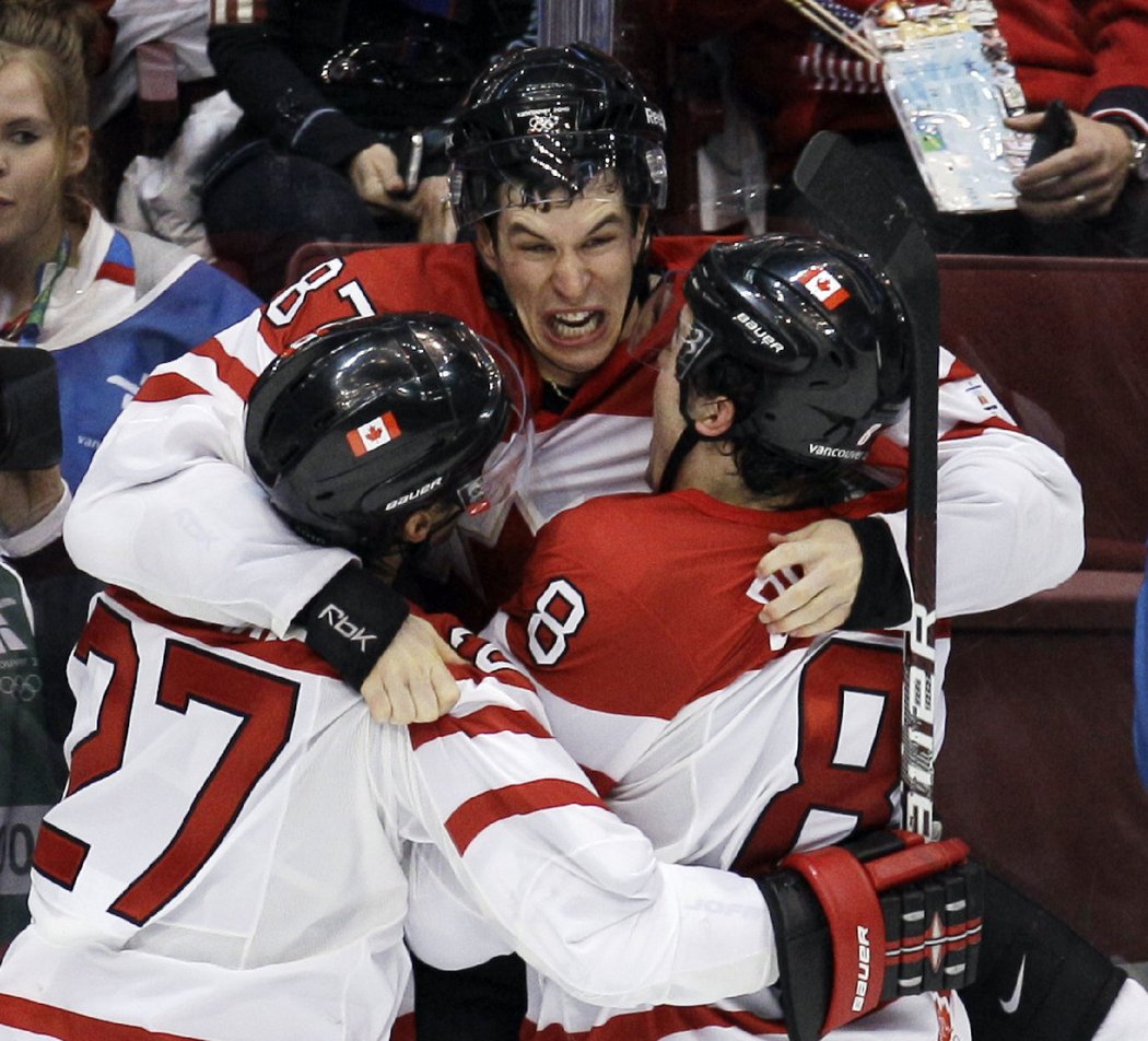 Drew Doughty a Chris Pronger se vrhají na Sidneyho Crosbyho po zlatém gólu ve finále olympiády