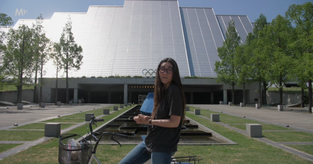 Naomi Adachi vás provede současným Naganem. Za ní stojí hala M-Wave, kde je dnes olympijské muzeum...