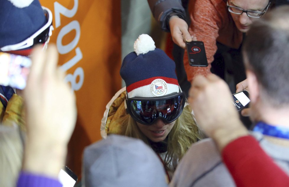 Ester Ledecká v obklopení novinářů po zlatém superobřím slalomu.
