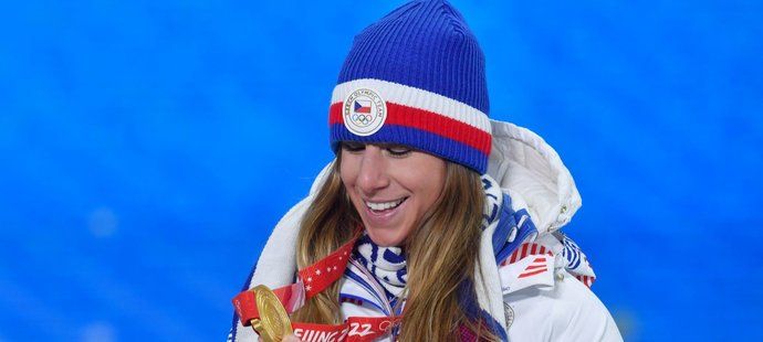 Ester Ledecká si prohlíží svou třetí zlatou olympijskou medaili