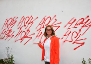 Lucie Zemanová (39) ukazuje poničenou zeď vedle jejího obchodu.