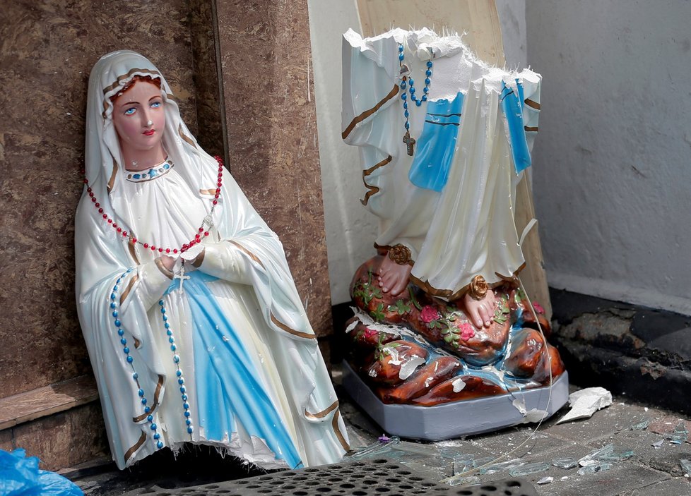 Rozbitá soška Panny Marie u jednoho z kostelů, na který zaútočili teroristé.