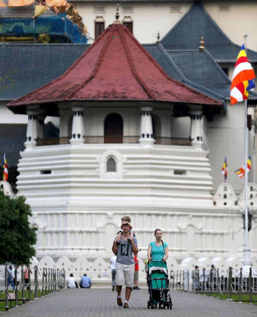 Turisté procházejí kolem budhistického chrámu ve srílanském městě Kandy, kde je podle tradice uložen Budhův zub