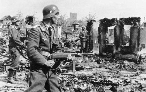 Příslušníci Wehrmachtu postupují ruinami města.