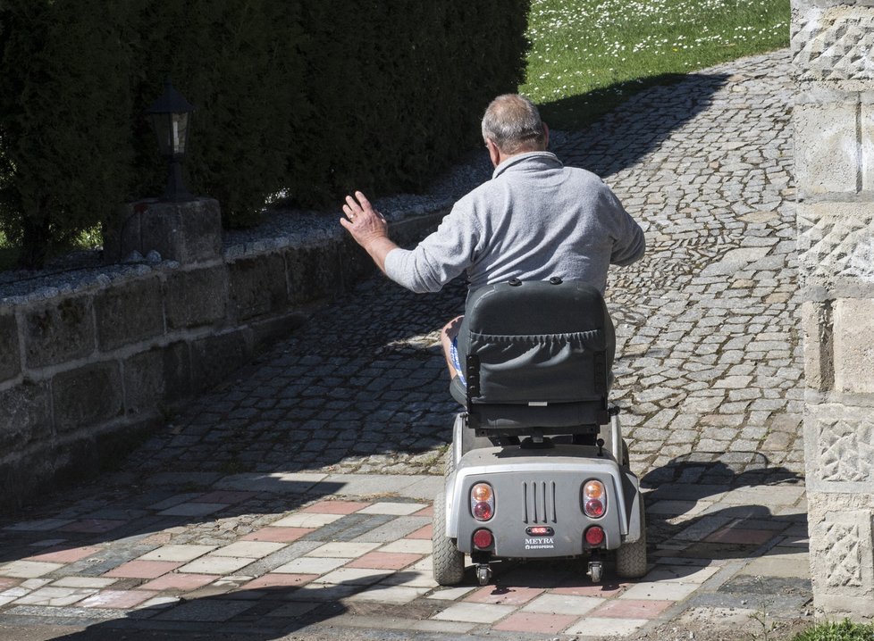 Grossův tatínek jezdí na elektrickém vozíku.