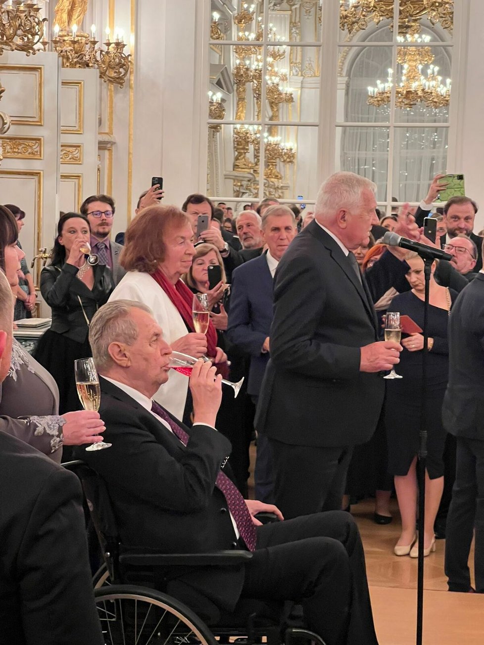 Recepce po udílení státních vyznamenání: prezident Miloš Zeman s manželkou Ivanou a jeho předchůdce Václav Klaus s manželkou Livií.